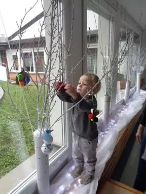 Okraševanje zasneženih dreves z novoletnimi okraski - praznična dekoracija veznega hodnika